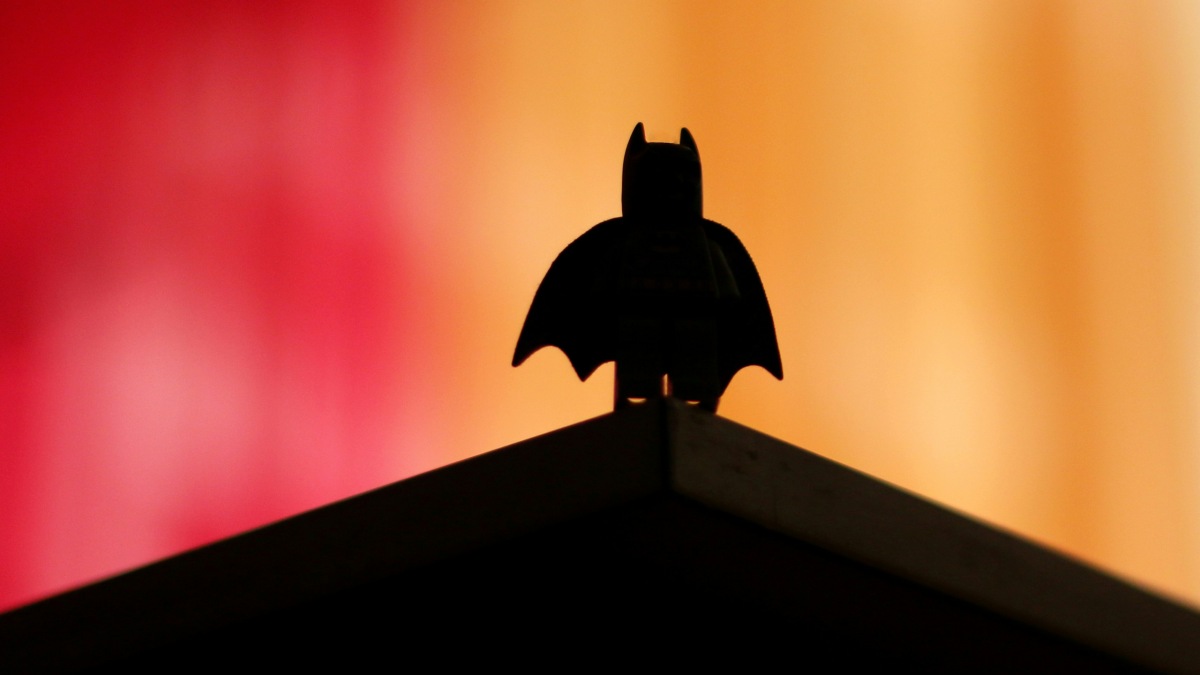 
a batman figurine against a colorful backdrop representing the hero in all of us
