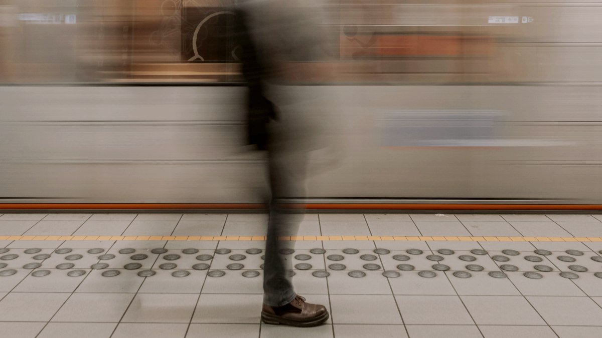 
A blurry photo of a man waiting for a train
