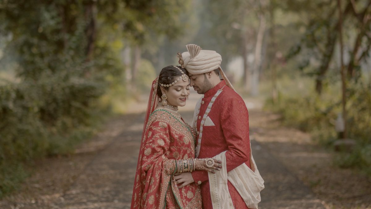 
A bride and groom standing on a path in the woods by iKshana Productions
