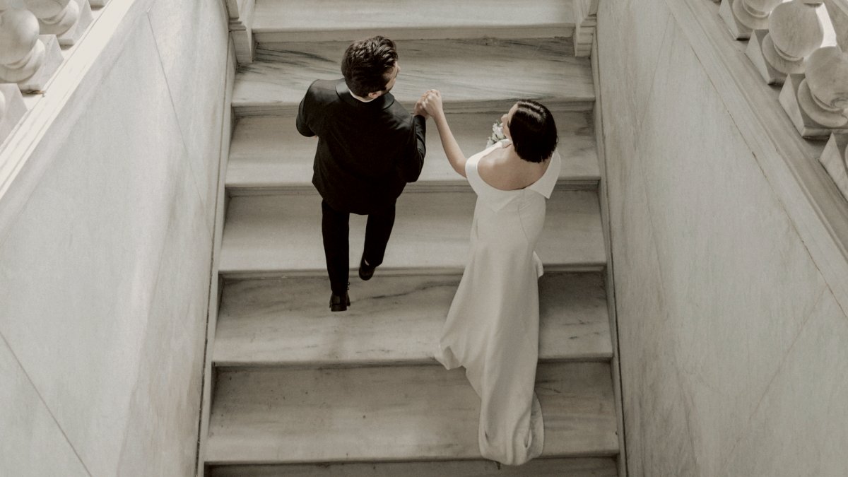 
a bride and groom walking down a flight of stairs
