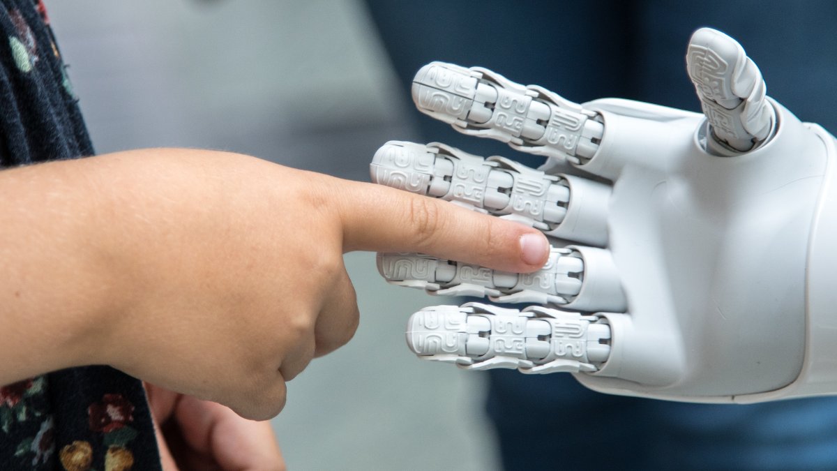 
a child extending her hand out to a robot hand symbolyzing new beginnings and the potential of the AI revolution
