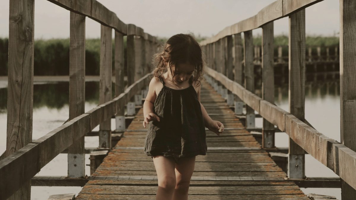 
a-child-walking-on-a-pier
