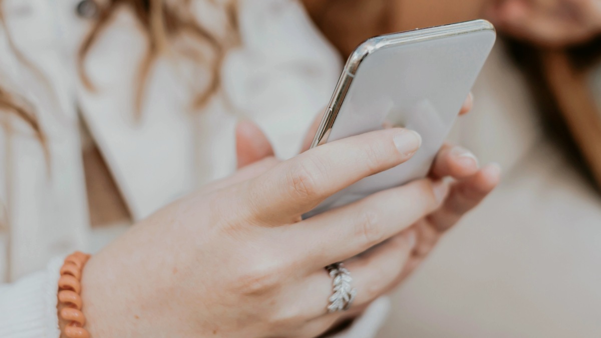 
a close up of a person holding a cell phone sending a text
