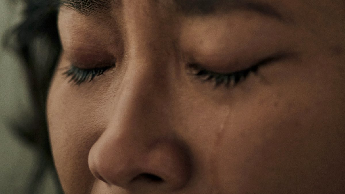 
a close up of a person with a tear rolling down their cheek
