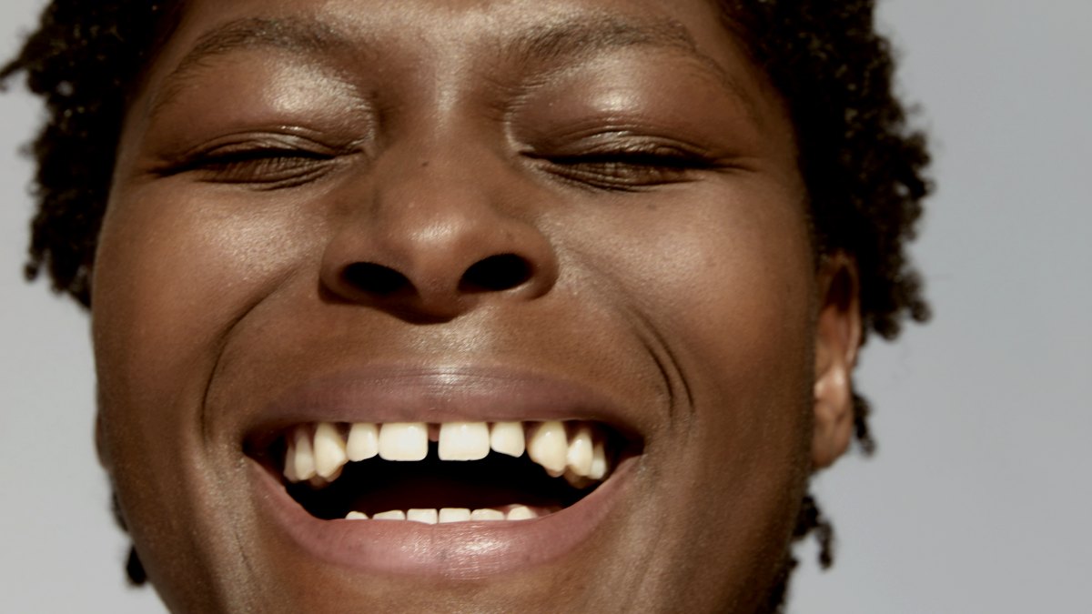 
a close up of a woman smiling and laughing with her eyes closed
