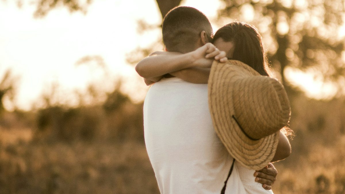 
a-couple-in-each-others-arms-during-sunset
