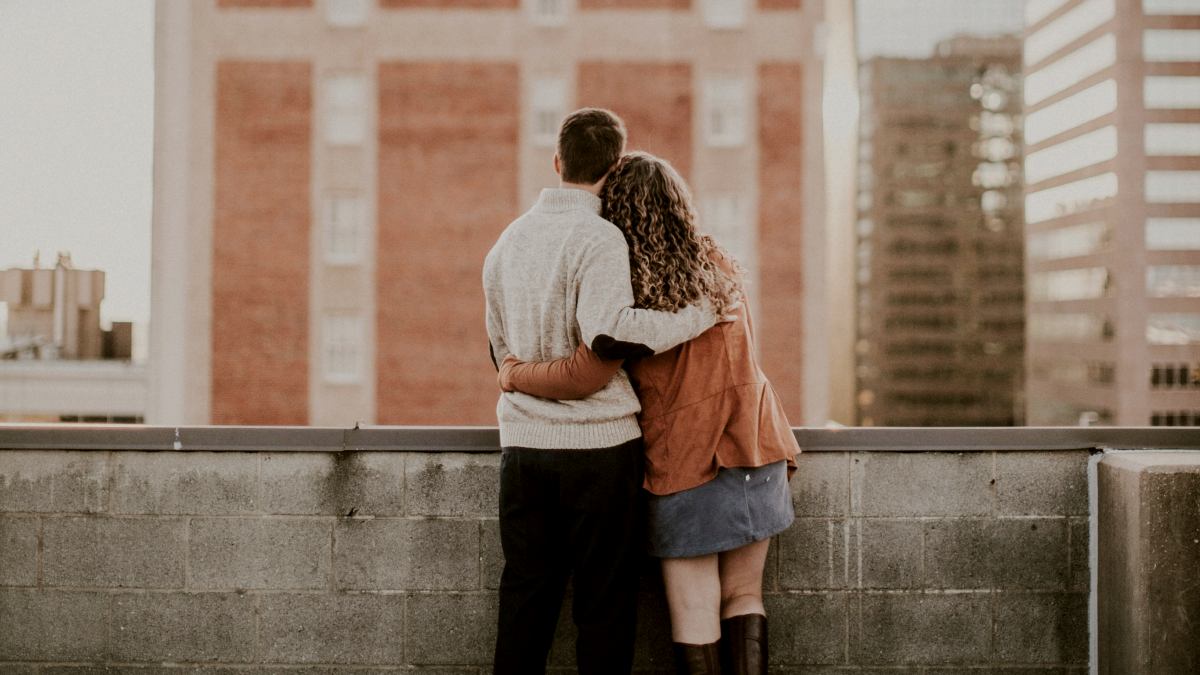 
a-couple-in-their-honeymoon-phase-standing-on-a-roof
