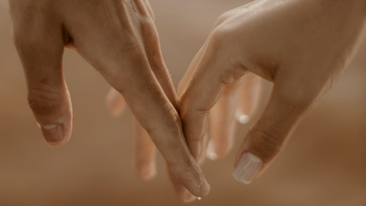 
a couple of people holding hands over a body of water with wet hands by JSB Co
