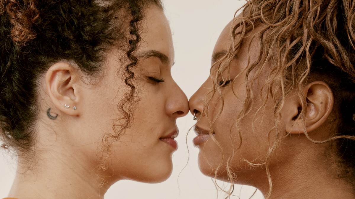 
a couple of women in an embrace standing in front of each other by Natalia Blauth
