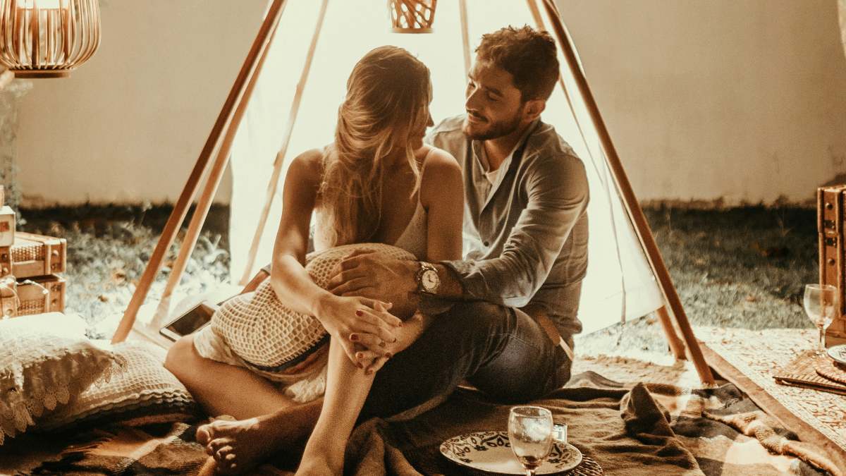 
a-couple-sitting-under-a-tepee
