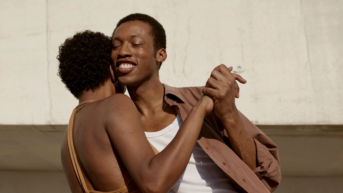 
a couple that are hugging each other while dancing outside
