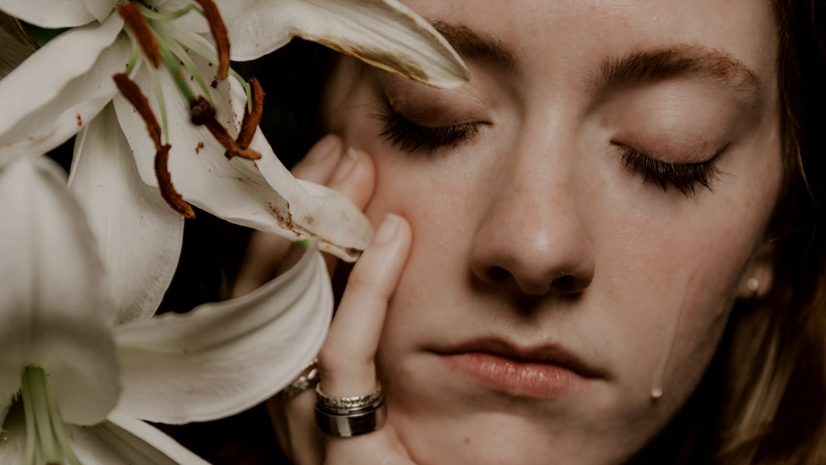 
a-crying-woman-holding-a-bouquet-of-white-flowers
