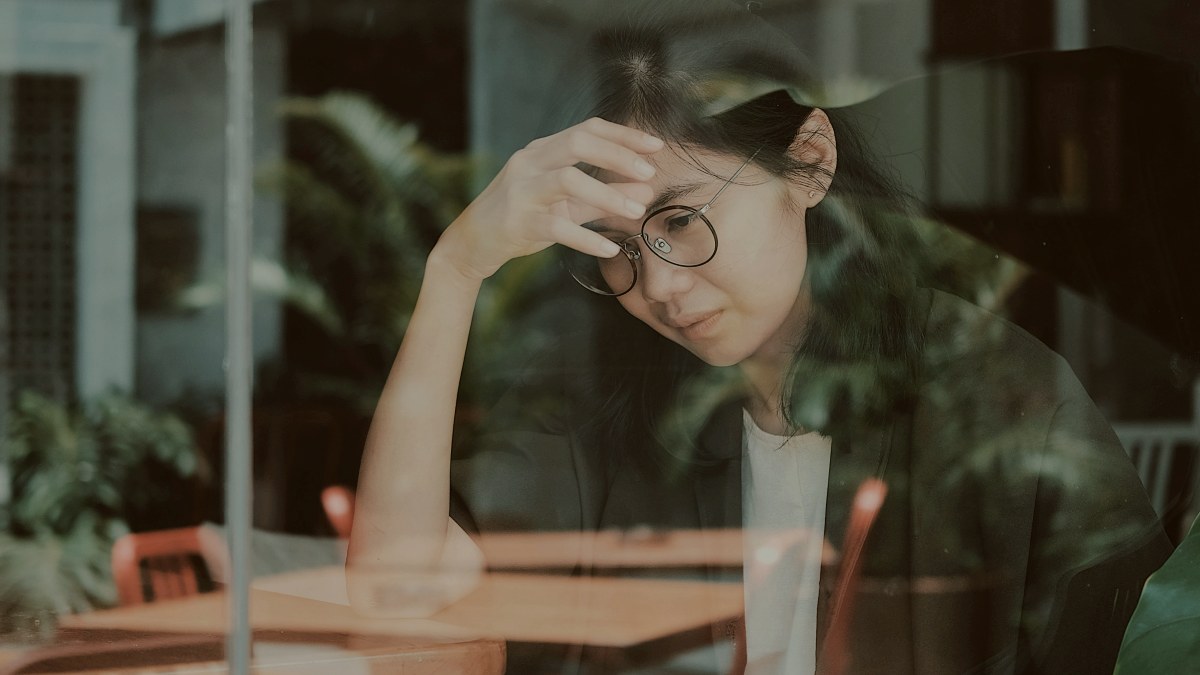 
a-depressed-woman-sat-in-a-cafe
