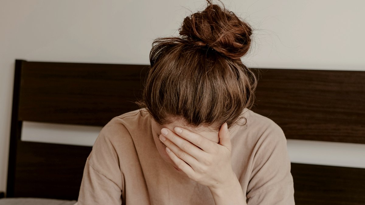 
a-depressed-woman-scrolling-on-her-phone-on-her-bed
