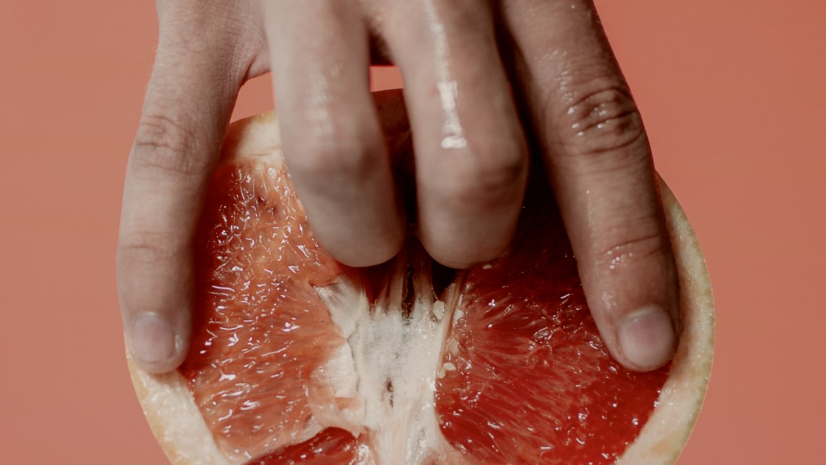 
a-hand-playing-with-a-grapefruit
