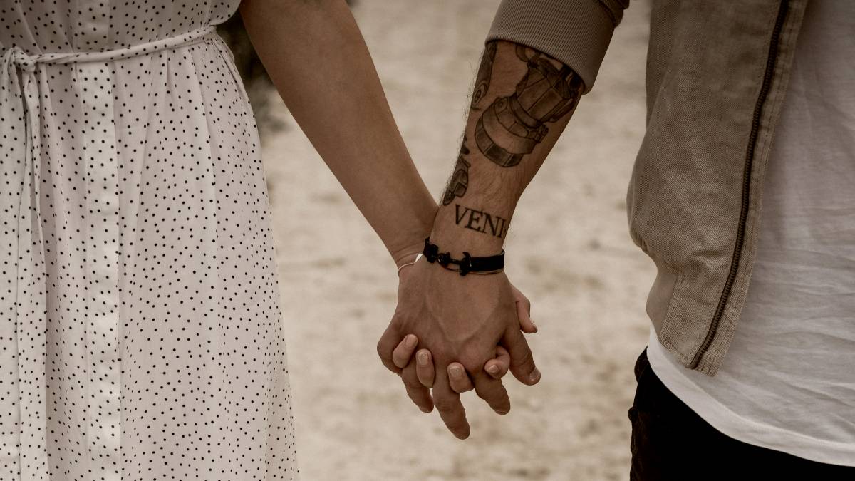 
a-happy-couple-holding-hands-on-a-dirt-road
