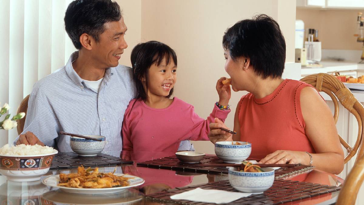 
A happy young family sharing a meal together to boost their sense of togetherness.
