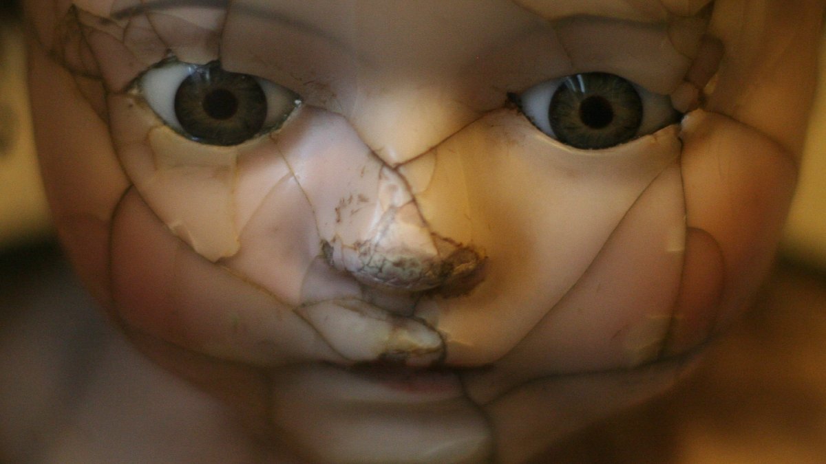 
a humanoid baby with a cracked face representing the uncanny valley of the cracked human facade
