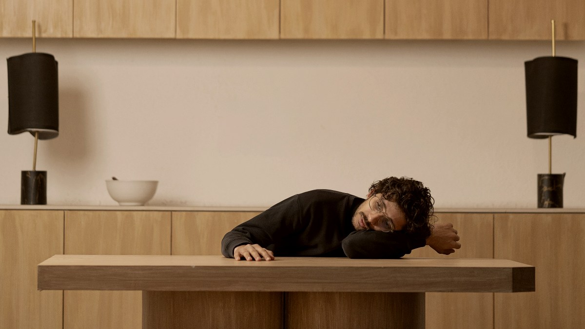 
A lonely man resting on top of a wooden table
