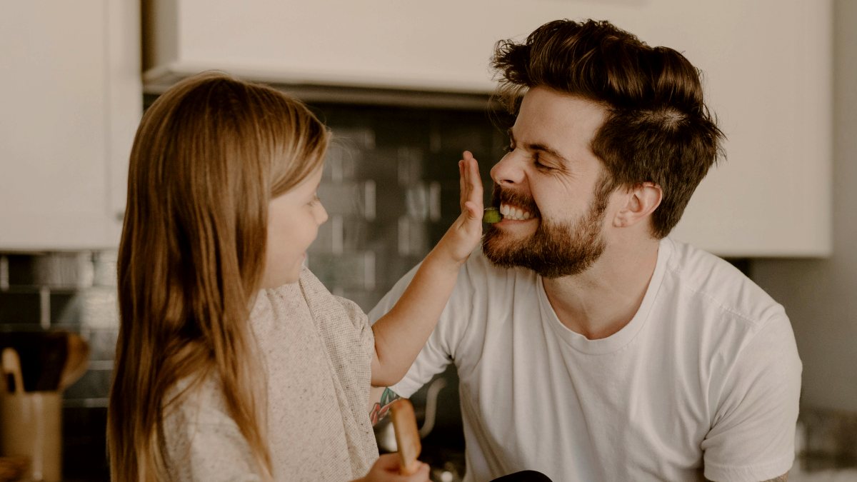 
a man and a little girl sitting on a kitchen counter
