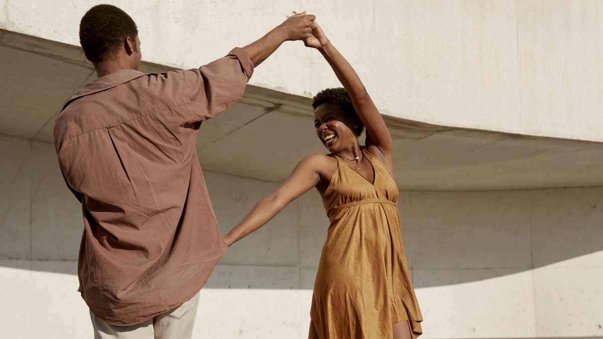 
a man and a woman dancing together in front of a building
