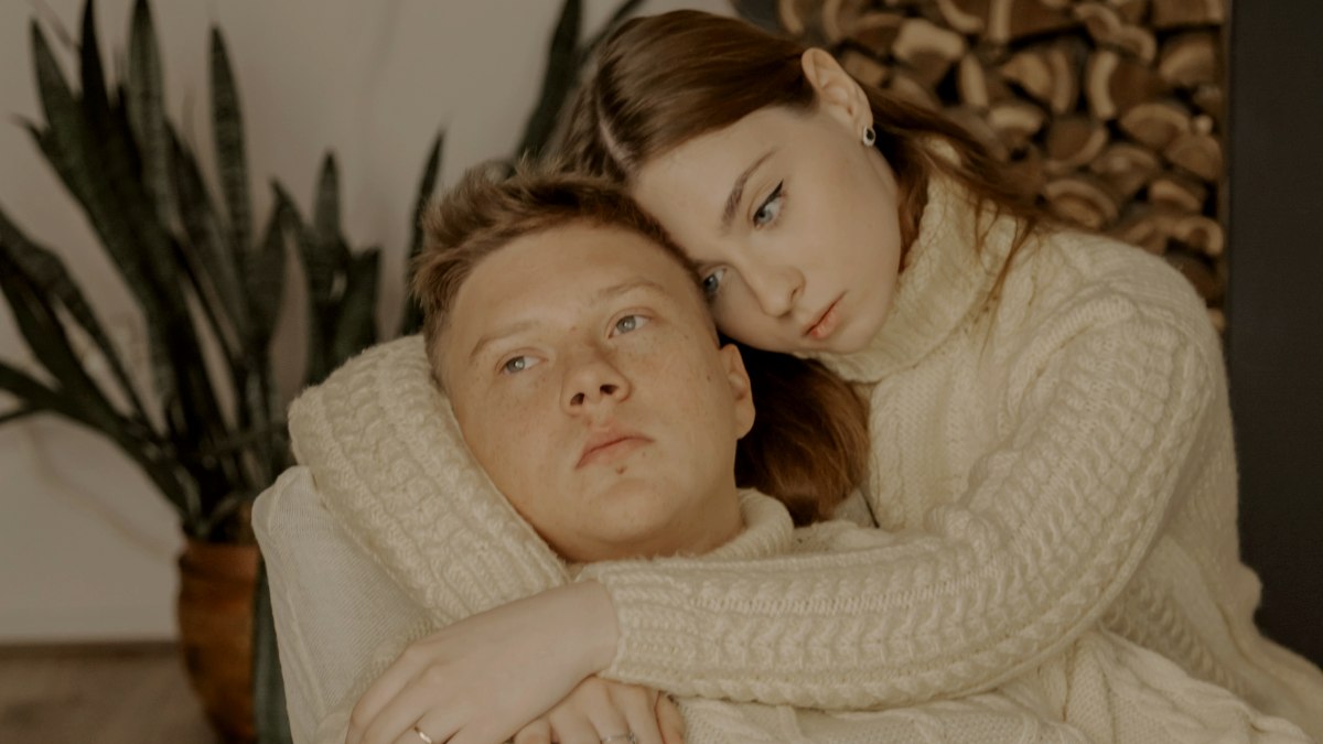 
a man and a woman laying on a couch together
