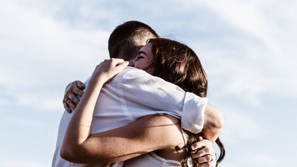 
a man and a woman sharing a warm embrace after overcoming their issues
