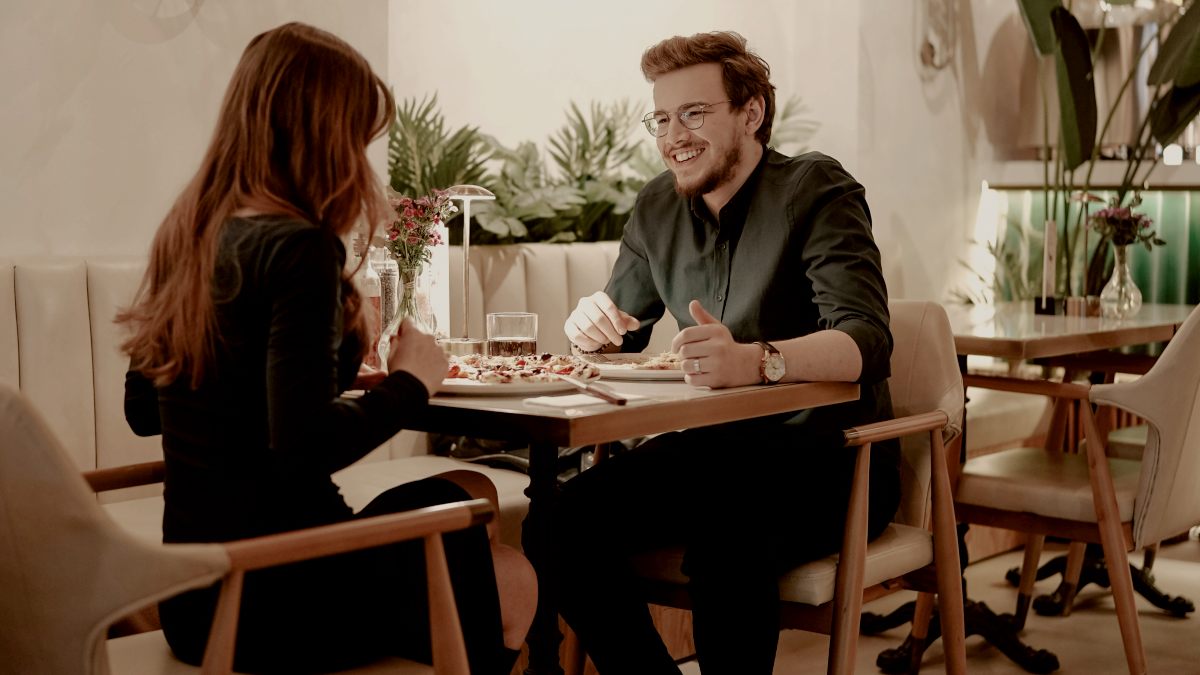 
a man and a woman sitting at a table in a restaurant on a date Yunus Tuğ
