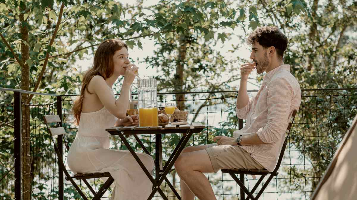 
A man and a woman sitting at a table on a deck
