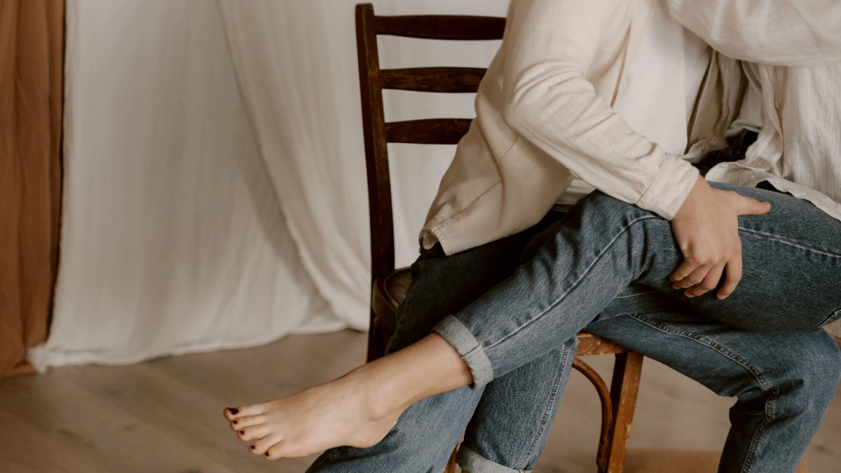 
a man and a woman sitting on a chair intimately
