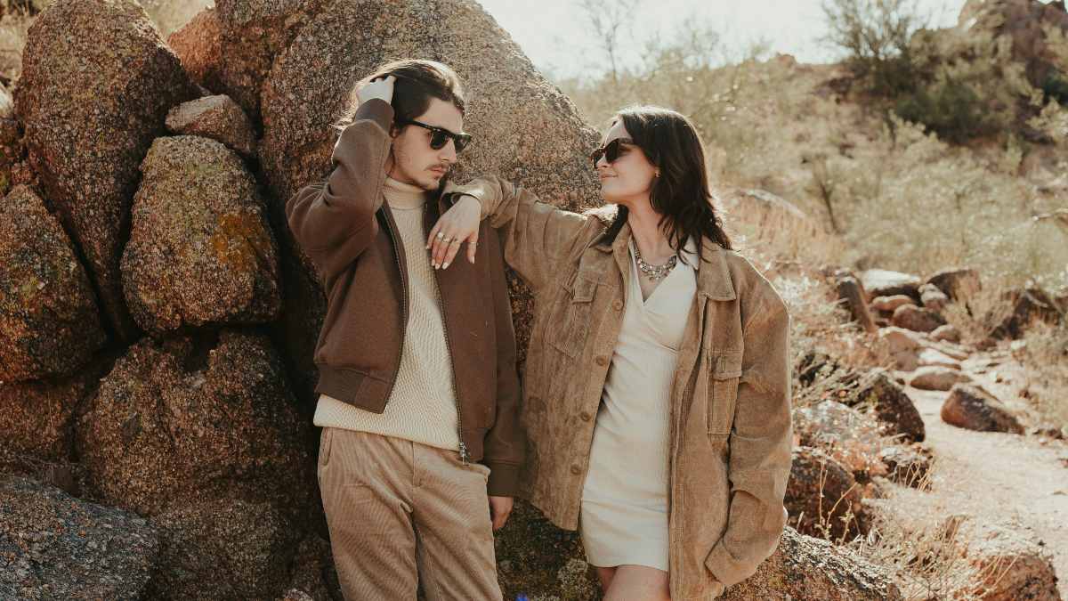 
A man and a woman standing next to a pile of rocks
