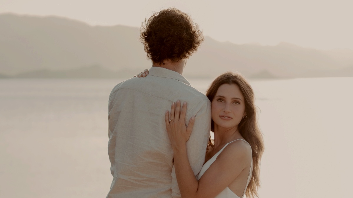 
a man and a woman standing next to each other by body of water by Wesley Tingey
