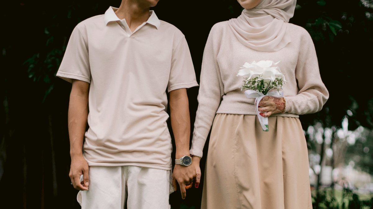 
a man and a woman standing next to each other in a garden
