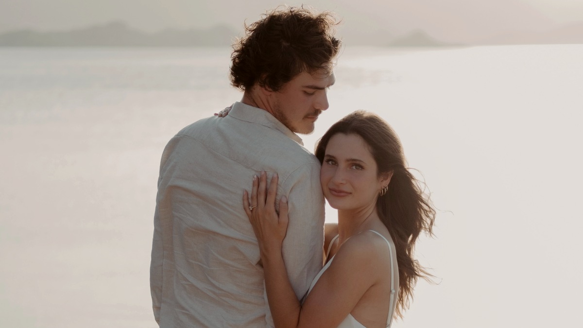 
a man and a woman standing next to each other on a beach by Wesley Tingey
