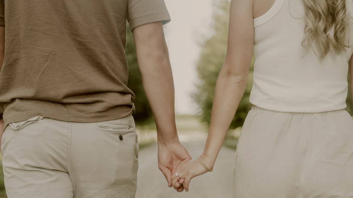 
a man and a woman walking down a road holding hands by Adam Davis
