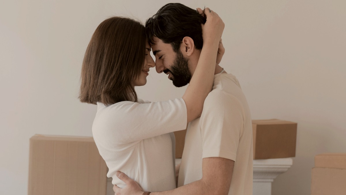 
a man and woman embracing in front of boxes
