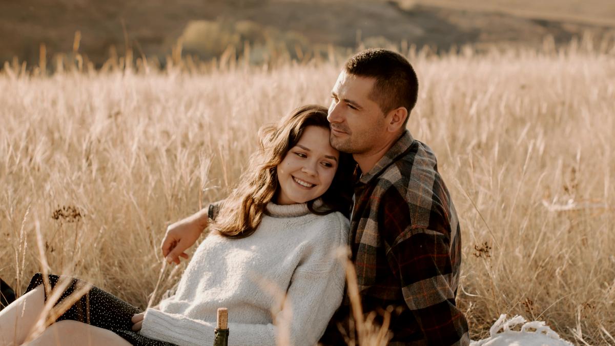 
a-man-and-woman-sitting-in-a-field-of-tall-grass
