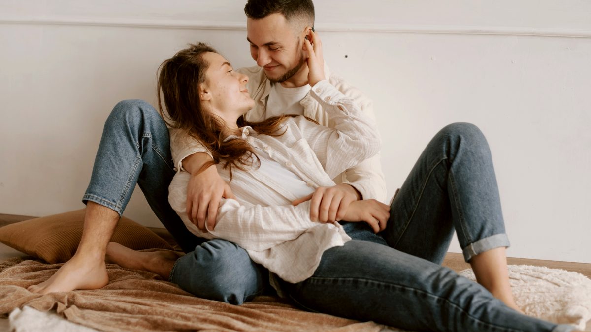 
a man and woman sitting on the floor together
