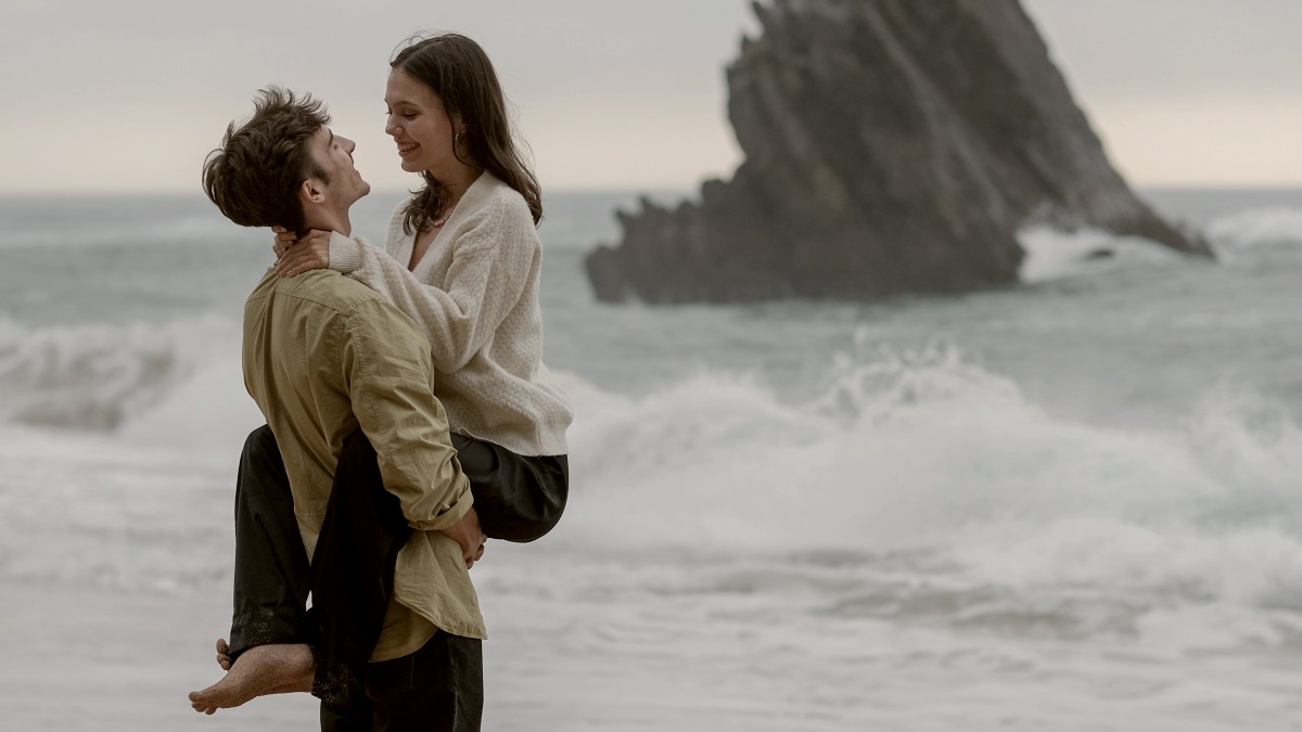 
a-man-carrying-a-woman-on-his-back-on-the-beach
