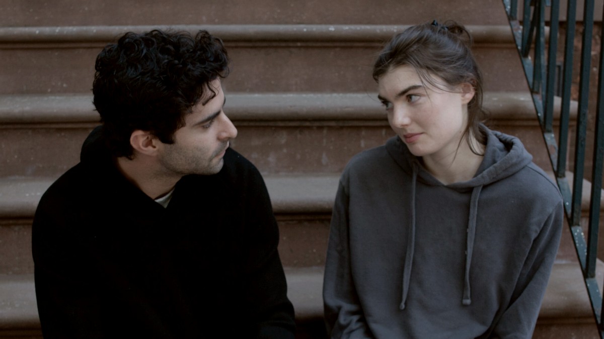 
a man sitting next to a woman on the steps by Gabriel Ponton
