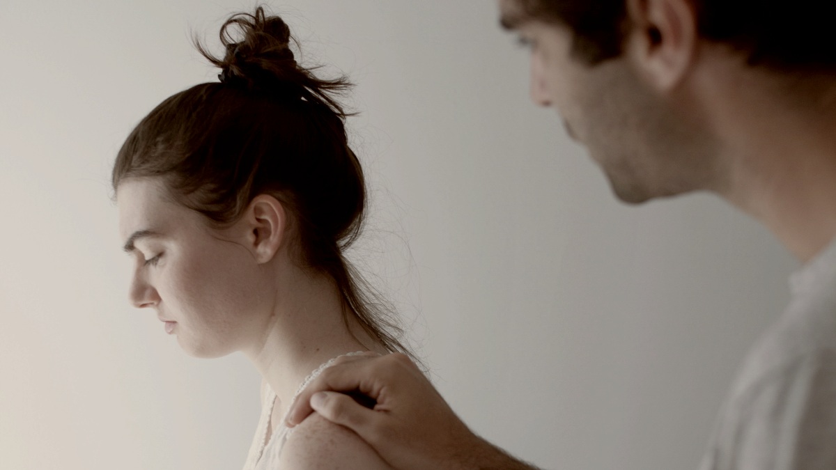 
a man standing next to a woman on a bed his hand on her shoulder by Gabriel Ponton
