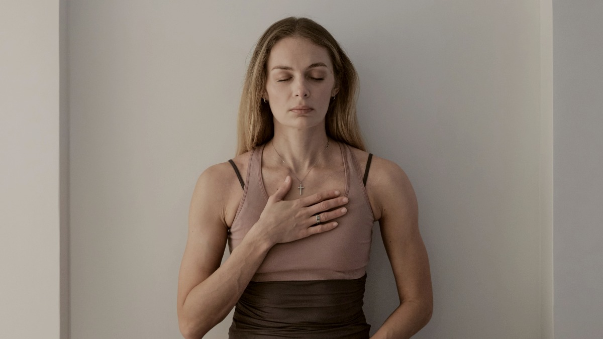 
a meditating woman sitting on a white surface
