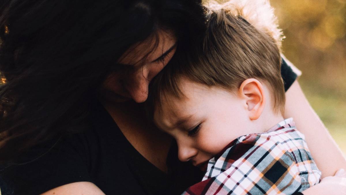 
a mother holding her son tightly for emotional support and comfort

