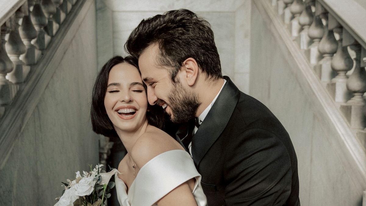 
a newlywed couple are hugging on the stairs of their wedding venue
