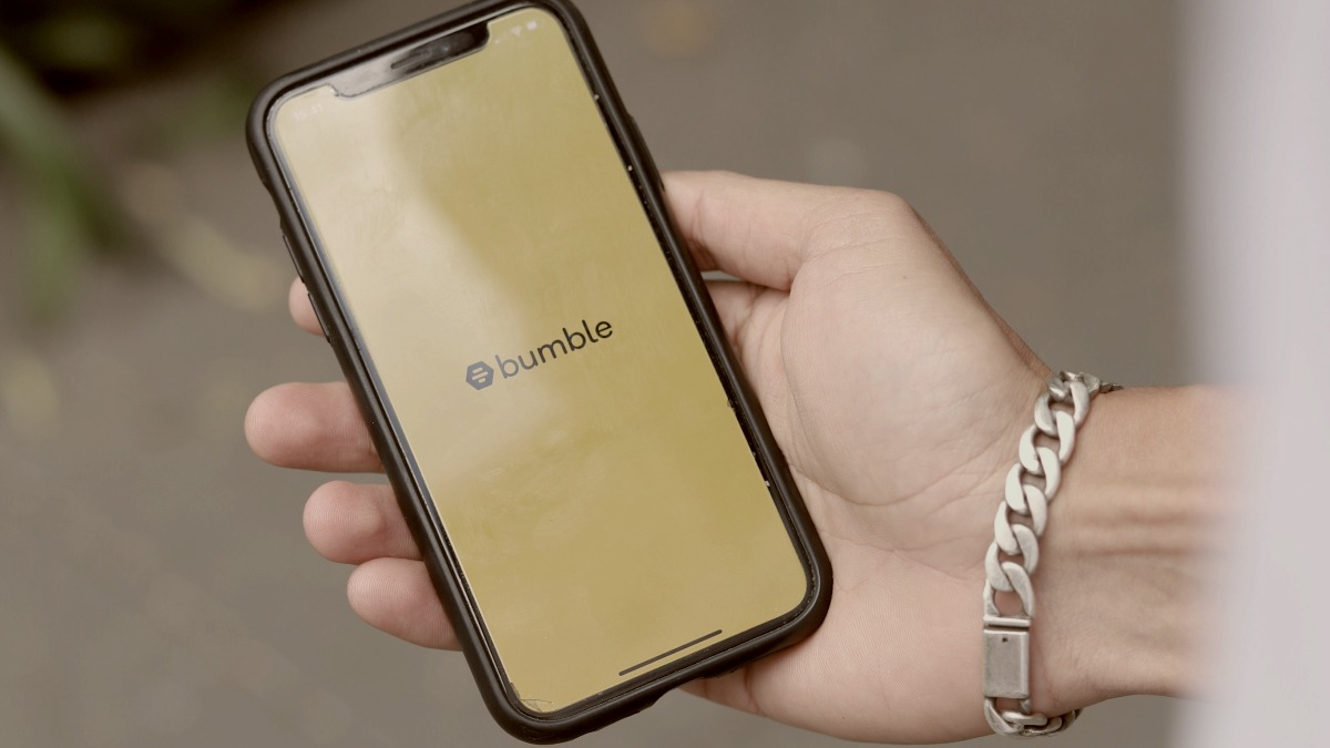 
a person holding a cell phone in their hand with bumble dating app by Good Faces Agency
