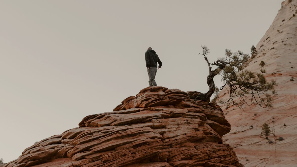 
a-person-standing-on-top-of-a-large-rock
