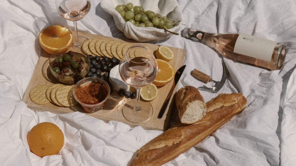 
a-picnic-with-sliced-fruits-and-breads-and-rose
