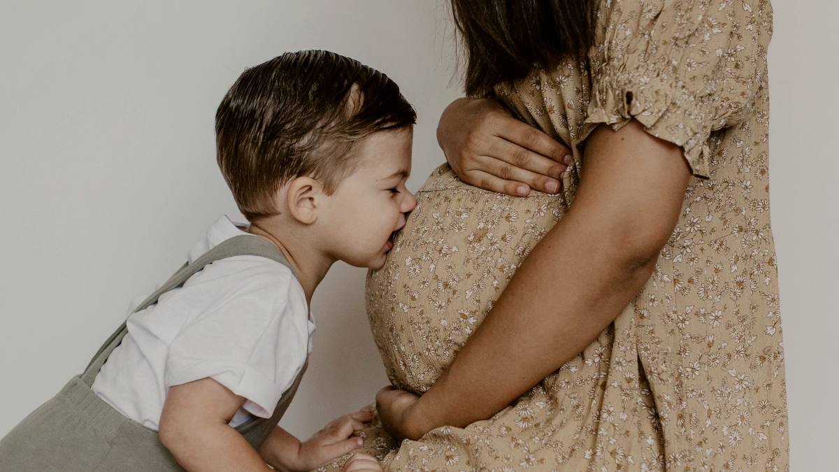 
a-toddler-kissing-his-pregnant-mothers-belly
