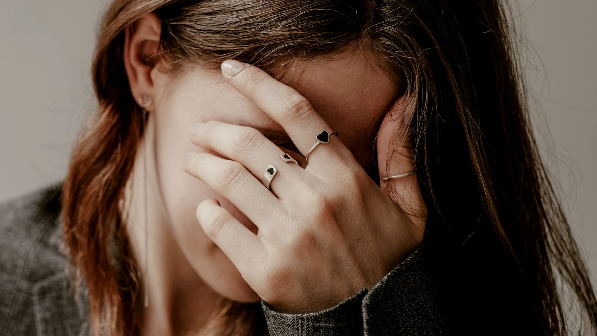 
a woman covering her face with her hands by Valeriia Miller
