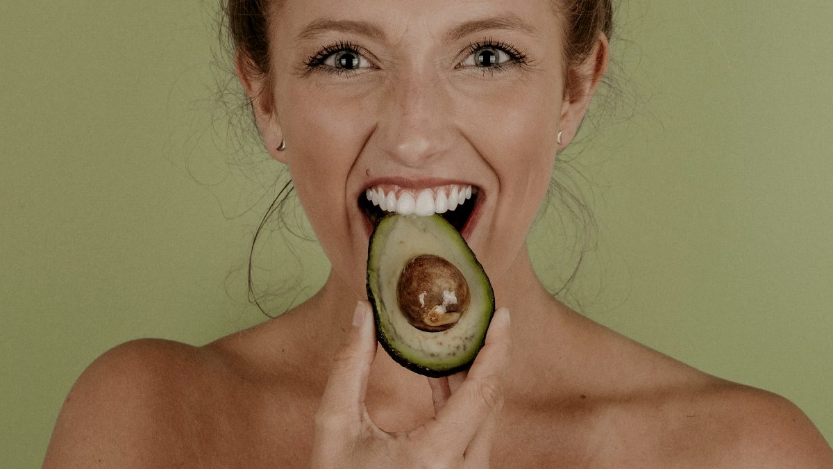 
a-woman-eating-an-avocado
